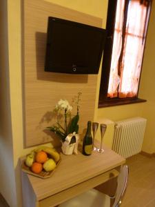 een tafel met een fruitmand en een televisie bij Casa Giardinetto in Stresa
