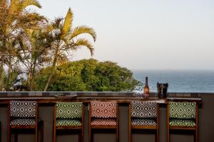 een fles wijn op een balkon met uitzicht op de oceaan bij Hillside Guesthouse Umhlanga in Durban