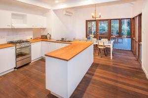 a kitchen with white cabinets and a wooden counter top at Buxton Thomas in Dunsborough