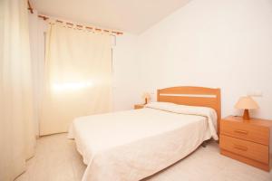 1 dormitorio con cama blanca y tocador de madera en Rentalmar Calas de Miami, en Miami Platja