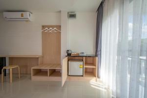 a room with a small table and a window at Happiness Guesthouse in Pak Chong