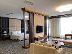 a hotel room with a bed and a television at Muong Thanh Luxury Son La in Sơn La