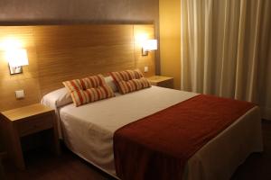 a hotel room with a large bed with two pillows at Hotel Carmen in La Cala de Mijas