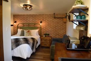 a bedroom with a bed and a brick wall at Bramblebank Cottages in Harrison Hot Springs
