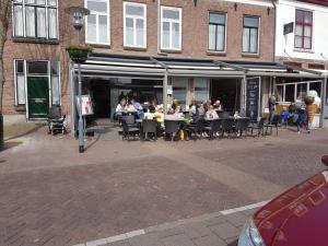 un groupe de personnes assises à des tables à l'extérieur d'un restaurant dans l'établissement Vakantiewoning Zonnige Blik, à Domburg