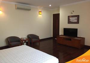 a bedroom with a bed and a flat screen tv at Zo Villas in Hanoi