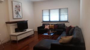 
a living room filled with furniture and a tv at Leisurely Manor in Fremantle
