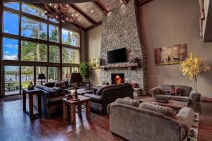 a living room with couches and a fireplace at Whispering Pines Lodge: 9 Bedroom in Eagle River