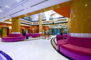 a lobby with purple chairs in a building at Golden Tulip Al Shakreen in Medina