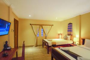 a hotel room with two beds and a flat screen tv at Villa D Riverside Boutique Hotel in Siem Reap