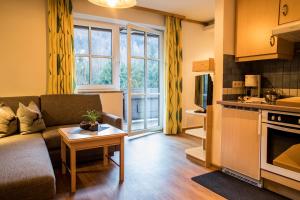 a living room with a couch and a table at Appartement Mühle - including Summercard, Sauna, Kaprun's largest private garden with panoramic view in Kaprun