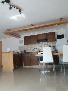 a kitchen with wooden cabinets and white chairs at Eifelflair in Retterath