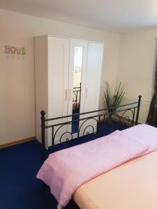 a bedroom with a bed with a pink blanket at Eifelflair in Retterath