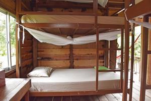 a bunk bed in a wooden room with a bunk bed in a house at Mad Monkey Koh Rong Samloem in Koh Rong Sanloem