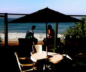 - une table et des chaises avec un parasol sur la plage dans l'établissement Beach Villa Randiya, à Galle