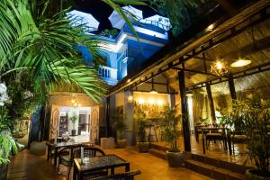 a restaurant with tables and chairs and plants at River Retreat Boutique Hotel in Siem Reap