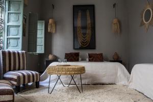 a bedroom with a bed and a table and a chair at Riad Danka in Marrakesh +105 photos
