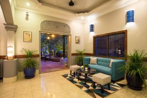 a living room with a blue couch and plants at Villa D Riverside Boutique Hotel in Siem Reap