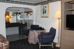 Habitación de hotel con mesa, sillas y sala de estar. en Best Whittier Inn, en Whittier