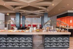 a restaurant with a counter with food on it at Good Morning Gelsenkirchen City in Gelsenkirchen