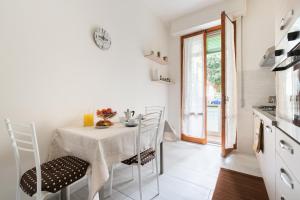 Careggi Home في فلورنسا: مطبخ أبيض مع طاولة وكراسي في غرفة
