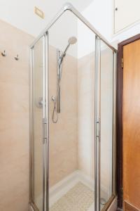 La salle de bains est pourvue d'une douche avec une porte en verre. dans l'établissement Careggi Home, à Florence