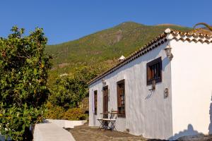 a white house with a mountain in the background at Finca Valentina in Tigalate