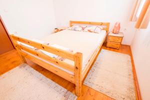 a bedroom with a wooden bed with white sheets at Holiday Home Juričko with private Sauna in Bizeljsko