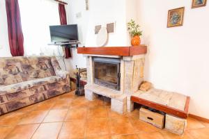 a living room with a stone fireplace and a couch at Holiday Home Juričko with private Sauna in Bizeljsko