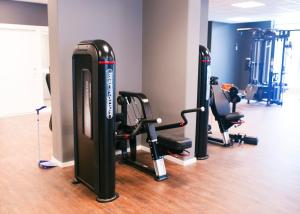 a gym with several treadmills and exercise bikes at Hotel Öresund Conference & Spa in Landskrona