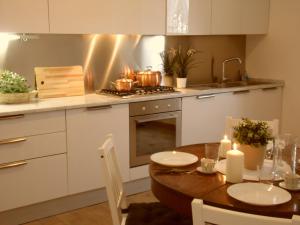 uma cozinha com uma mesa e um fogão com panelas e frigideiras em Casale Vallalta em Montefiascone