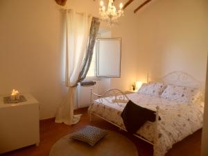 um quarto com uma cama e um lustre em Casale Vallalta em Montefiascone