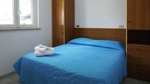a bedroom with a blue bed with towels on it at Camping Village Adriatico Giulianova in Giulianova +20 photos