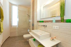 een badkamer met een wastafel, een toilet en een spiegel bij Lotsenstieg 2 Kajuete 03 in Ostseebad Karlshagen