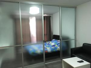 a living room with a glass partition with a bed at D Condo Nernpra Rayong in Rayong