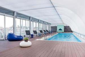 a large indoor pool in a building with windows at Hotel Baia in Cascais