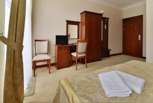 a bedroom with a bed and a desk and chairs at Hotel uluBIOny in Kostrzyn