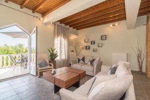 a living room with couches and a table at Villa Ismini in Zakynthos