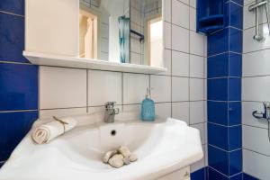 a bathroom with a white sink and a mirror at Villa Ismini in Zakynthos Town