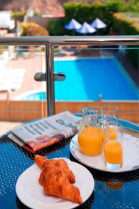 a table with two plates of food and orange juice at La Barbarie Hotel by Eight Continents in St. Martin Guernsey