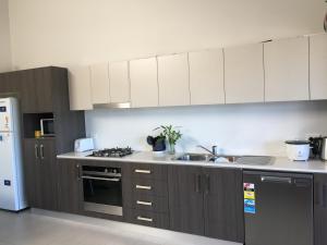 uma cozinha com armários castanhos e um frigorífico branco em Gosford Townhouse em Gosford