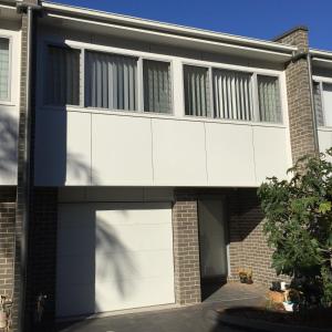 a white house with a garage at Gosford Townhouse in Gosford