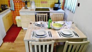 a kitchen with a table with plates and wine glasses at Apartment Romina in Pula