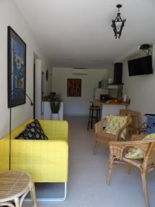レスカラにあるRez de Jardin près plage Riells L'Escalaのリビングルーム(黄色のソファ、椅子付)