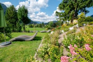 un jardín con tres bancos en el césped en Appartementhaus Leitner, en Ehrwald