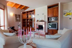 a living room with white furniture and a fireplace at Villa Principessa in Cremia