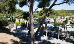 - une vue sur un parc avec une aire de jeux et des arbres dans l'établissement Camping Pascalounet, à La Couronne