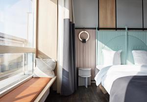 a bedroom with a bed and a window at CPH Hotel in Copenhagen