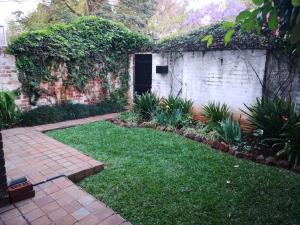 a garden with a brick wall and a brick walkway at MYSECONDHOME in Harare