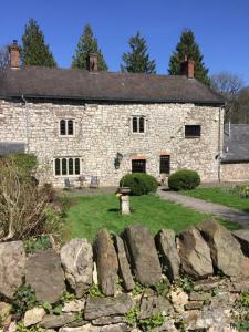 an old stone house with a stone wall at Pencoed House Estate (Cardiff) in Cardiff